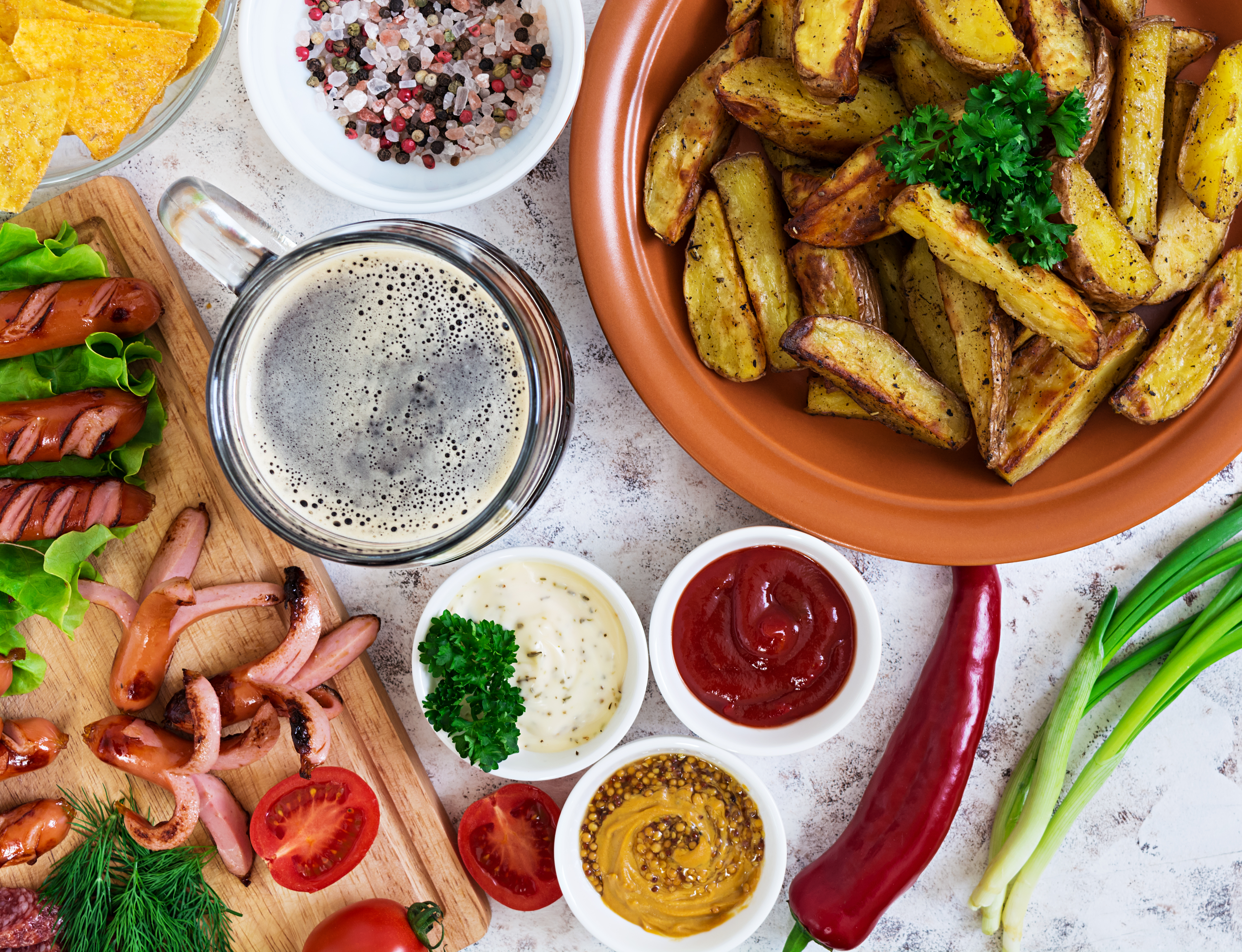 Baked potato wedges with sausages and spices. Top view