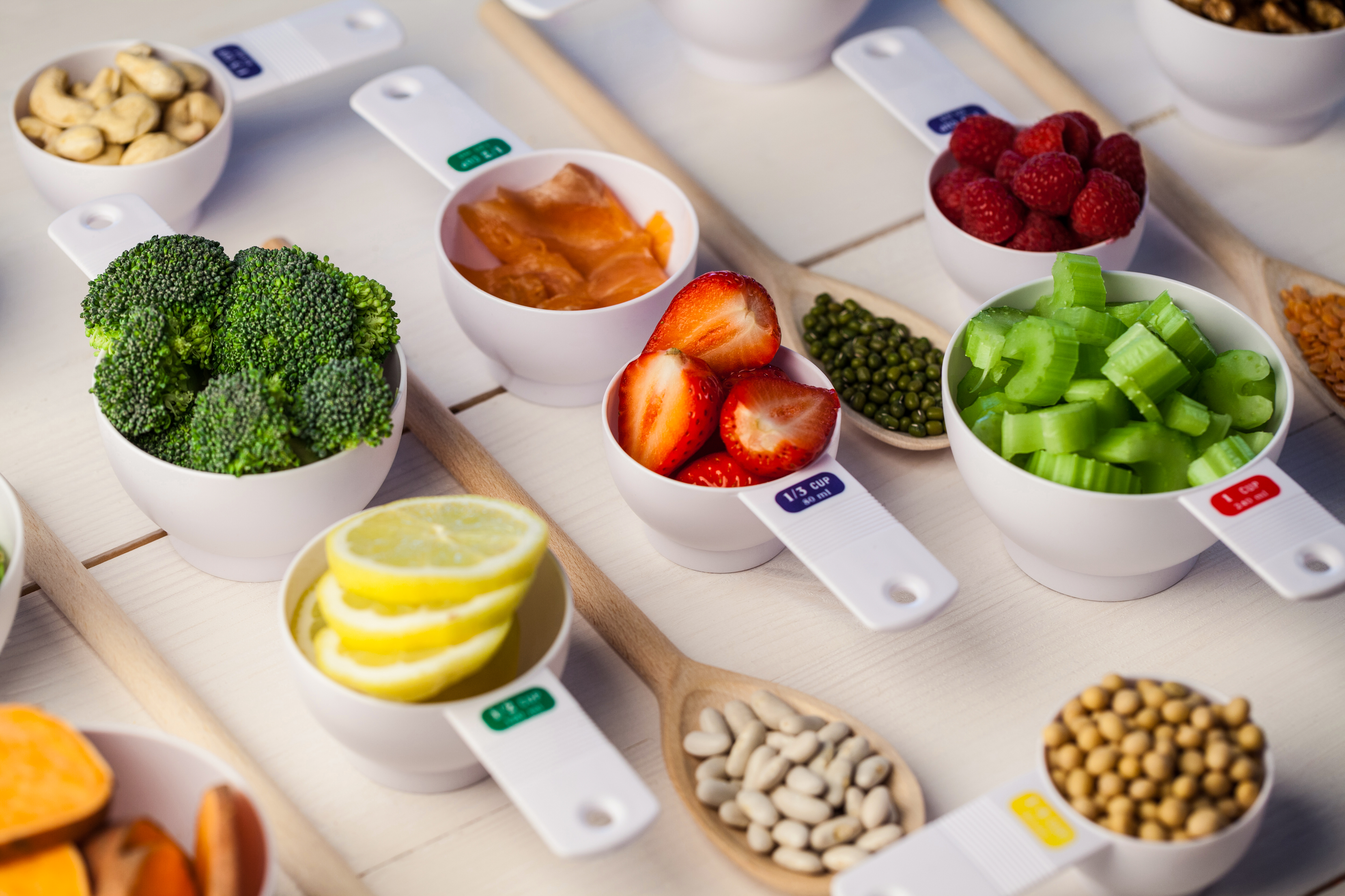 Portion cups of healthy ingredients on wooden table